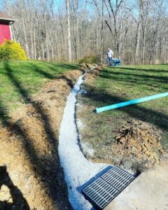 A pipe is being laid in a lawn as part of Anthony's landscape drainage service