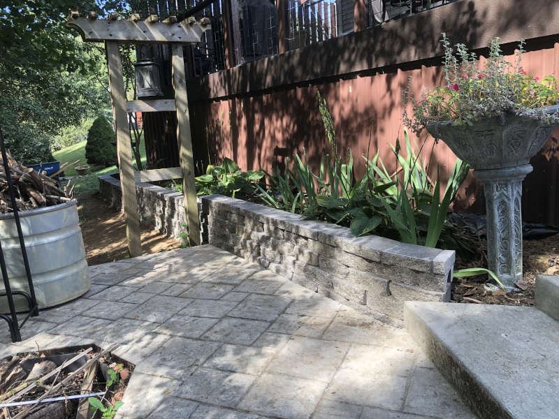 A backward patio with a retaining wall